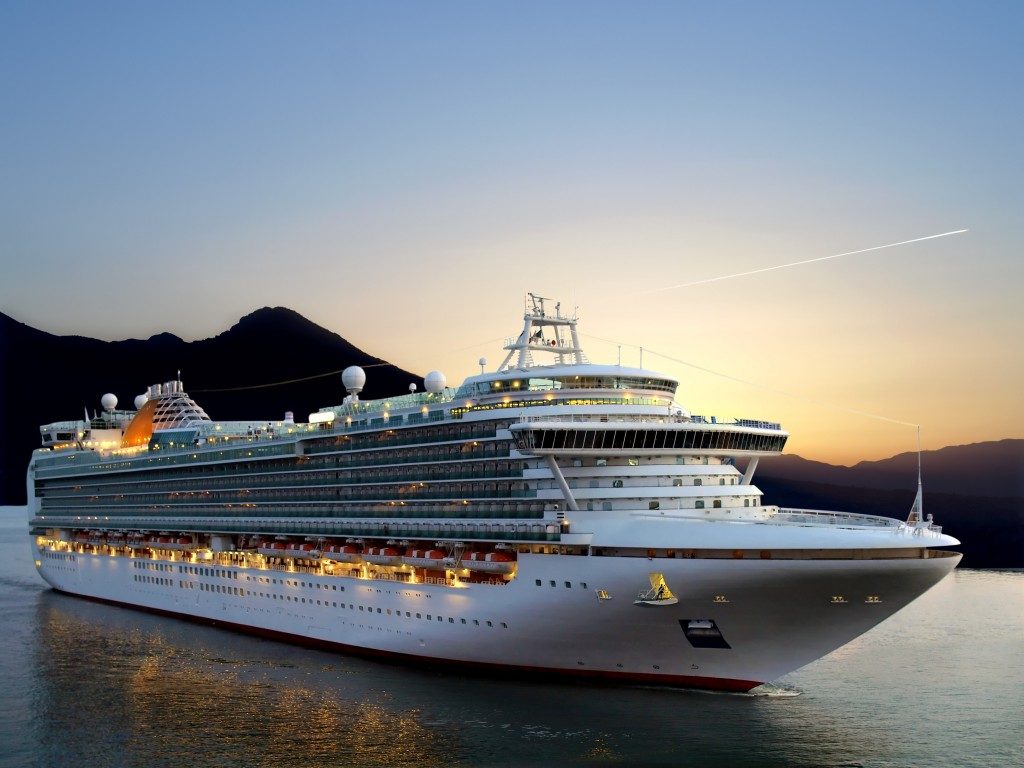 Luxury cruise ship sailing from port on sunrise