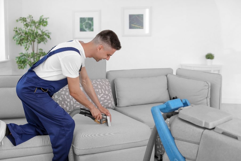 man cleaning a couch