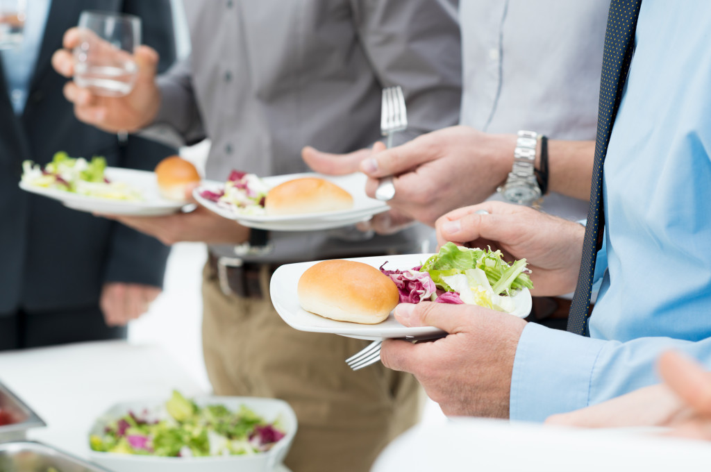 an office lunch with employees holding plates with healthy meals