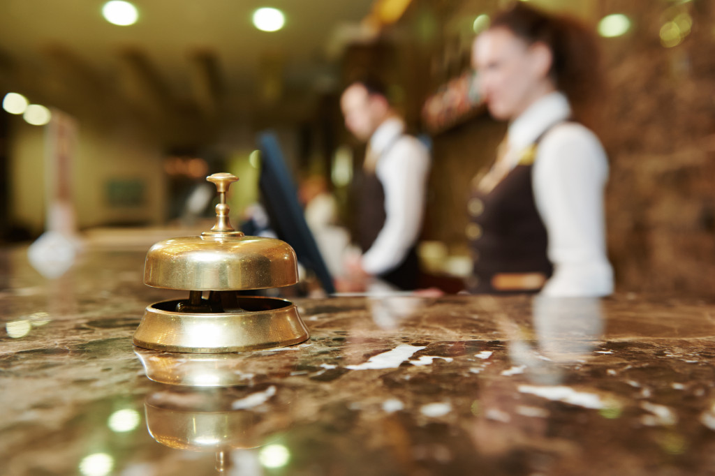 blurred view of a luxury hotel reception with bell on the foreground