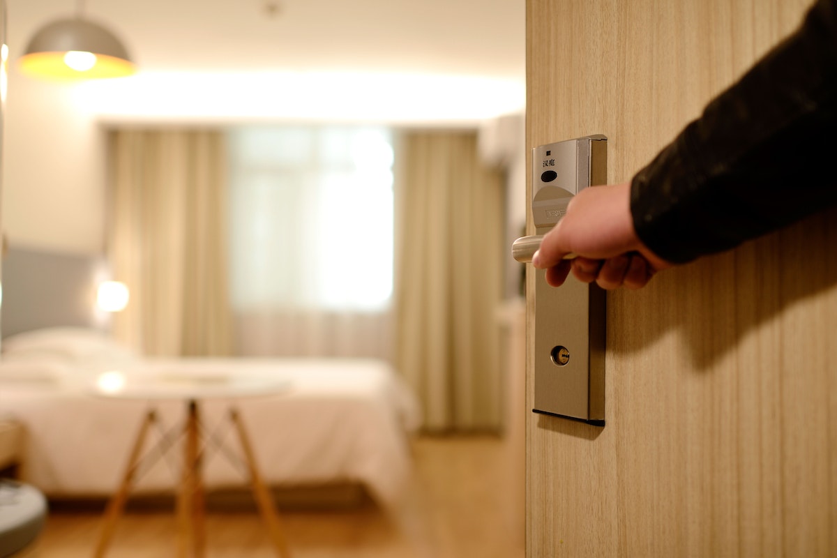 Person Holding on Door Lever Inside Room
